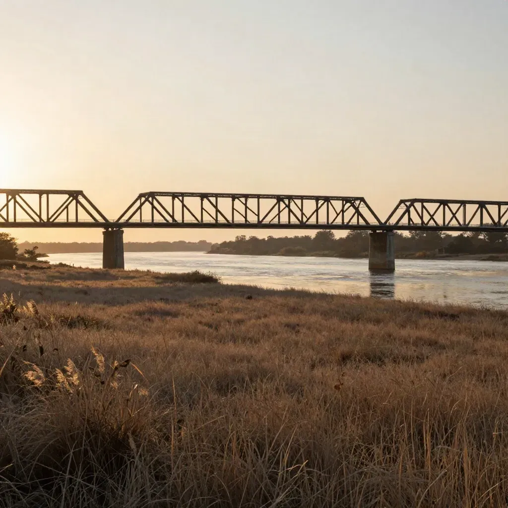 Sunset Brazos River bridge over open prairie near Waco in warm haze